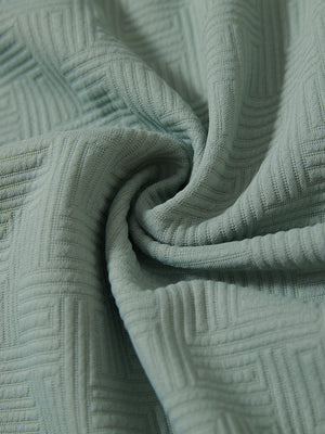 Close-up of fabric on textured insulated winter jacket, showing texture and finish in beryl green