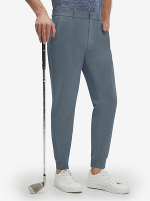 Front lower body shot of model wearing grey blue flat front golf joggers pants with belt loops