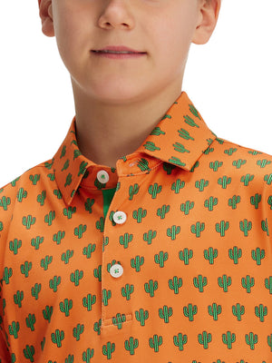 Close-up: nose to chest in orange cactus performance print boys golf polo