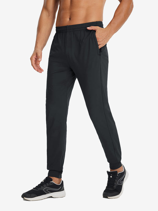 Side view of model with hand in pocket wearing lightweight traning track pants in black.
