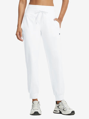 Model wearing women's stretch fleece lined water resistant joggers in white, showcasing the front lower body view.