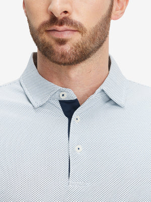 Close-up of a model wearing the navy feather weight jacquard polo shirts, focusing on the collar and face