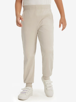 Model wearing light khaki fleece stretch water resistant boys joggers, front view showing lower body and pants.