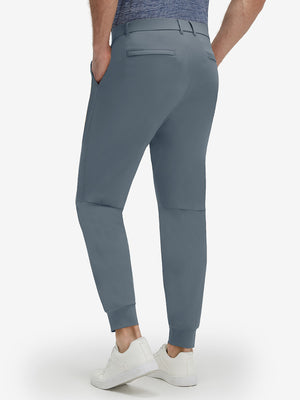 Back lower body shot of model wearing grey blue flat front golf joggers pants with belt loops
