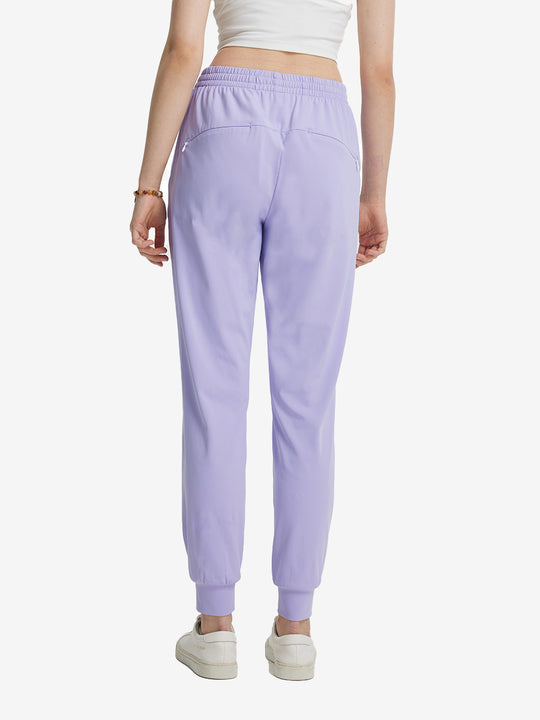Back view of lightweight women's stretchy joggers sweatpants on model, shown in lavender purple.