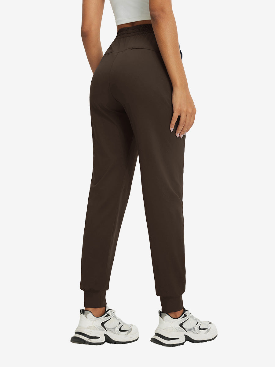 Back view of lightweight women's stretchy joggers sweatpants on model, shown in coffee brown.