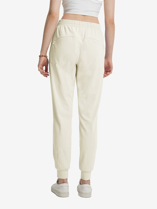 Back view of lightweight women's stretchy joggers sweatpants on model, shown in cream.