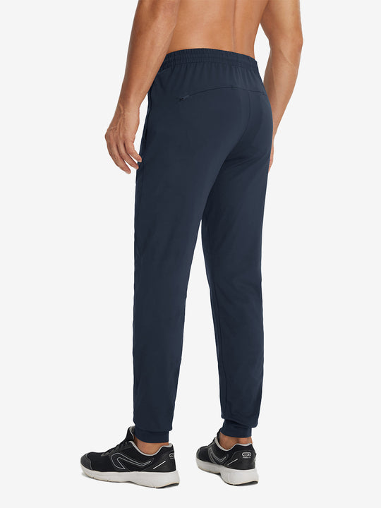 Back lower-body view showing lightweight traning track pants on model in navy.