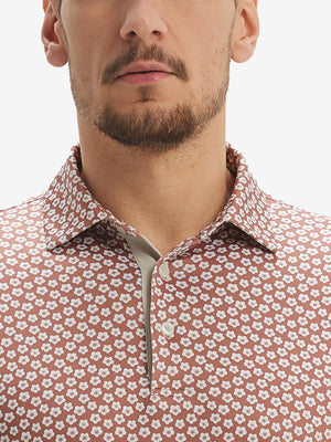 Front view from nose to chest of model wearing brick white flower performance quick dry print golf polos