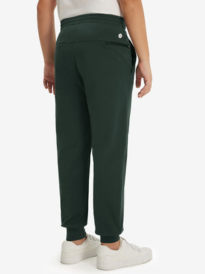 Model's lower body from the back, wearing forest green fleece stretch water resistant boys joggers.