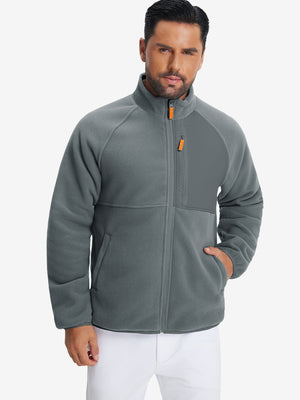 Model wearing the reversible fleece jacket with 5 pockets in dark grey, casually posing with one hand in the pocket for a stylish, practical look.