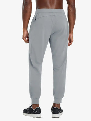 Back lower body view of model wearing LIGHT GREY Performance Tapered Sports Joggers