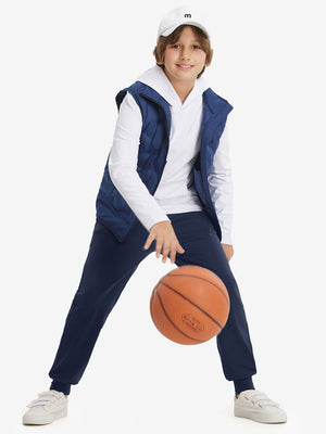 Full-body shot of model wearing navy fleece stretch water resistant boys joggers while playing basketball.