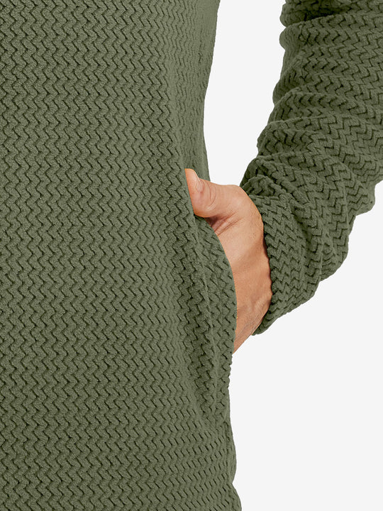 Close-up of pocket detail on midweight warm stretchy quarter zip pullover in green, showing neat stitching.