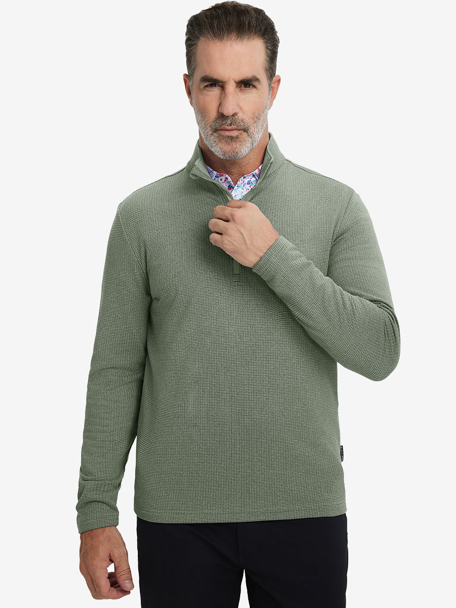 Model grabbing half-zip collar, wearing casual fleece lined quarter zip pullover in green.