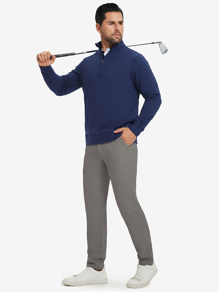 Model in dark blue top holding golf club on shoulder wearing lightweight moisture wicking dress pants in dark khaki.