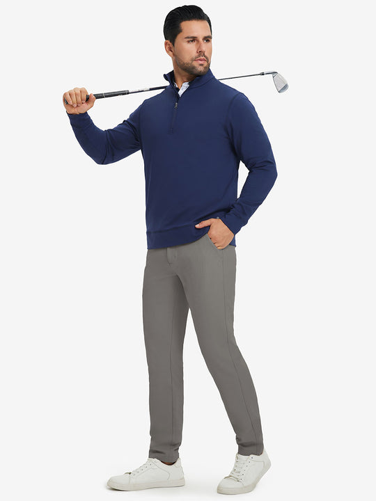 Model in dark blue top holding golf club on shoulder wearing lightweight moisture wicking dress pants in dark khaki.