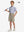 Full front: model in khaki grey boys lightweight dry fit flat front golf shorts holding golf club.