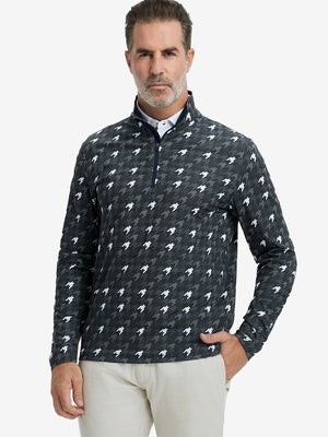 Front upper body view of model standing in grey houndstooth full print quarter zip pullover, relaxed look.