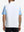 Back upper body shot of model wearing white lightweight sleeveless quarter zip golf vest