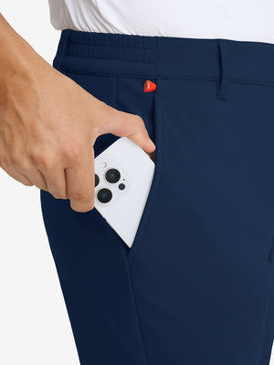 Close-up detail showing phone being placed in the pocket of navy water-resistant stretch heat-tech winter trousers