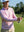Model swinging on golf course wearing full print lightweight quarter zip pullover in pink artichoke