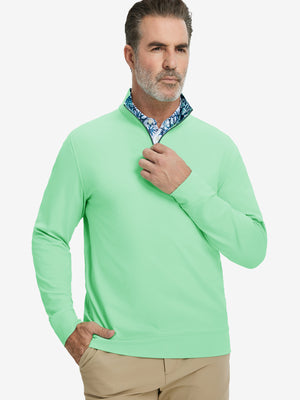 Front upper body view of model wearing lightweight golf quarter zip pullover in light green, relaxed fit.