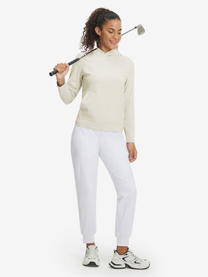 Model holding golf club, dressed in women's lightweight hoodies pullover in cream.