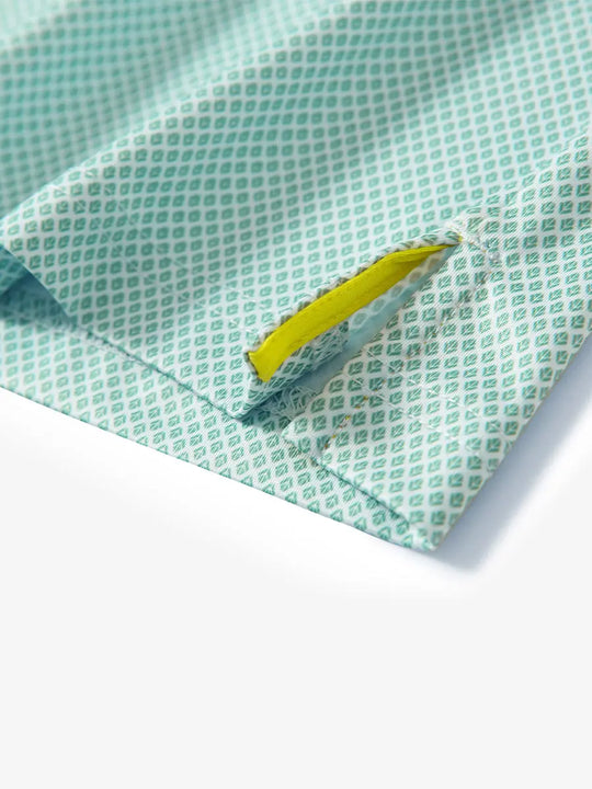 Detail view of the green plant pattern polo, focusing on the neatly finished hem opening and fresh design.