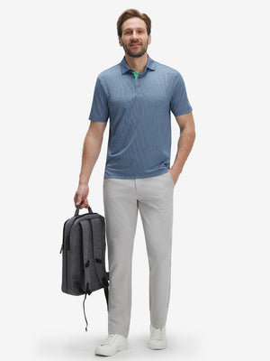Model with briefcase wearing Performance quick dry print golf polos in modern navy light blue ovals