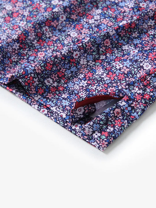 Detail view of the colorful floral pattern polo shirt, highlighting the neat hem opening and vibrant design.