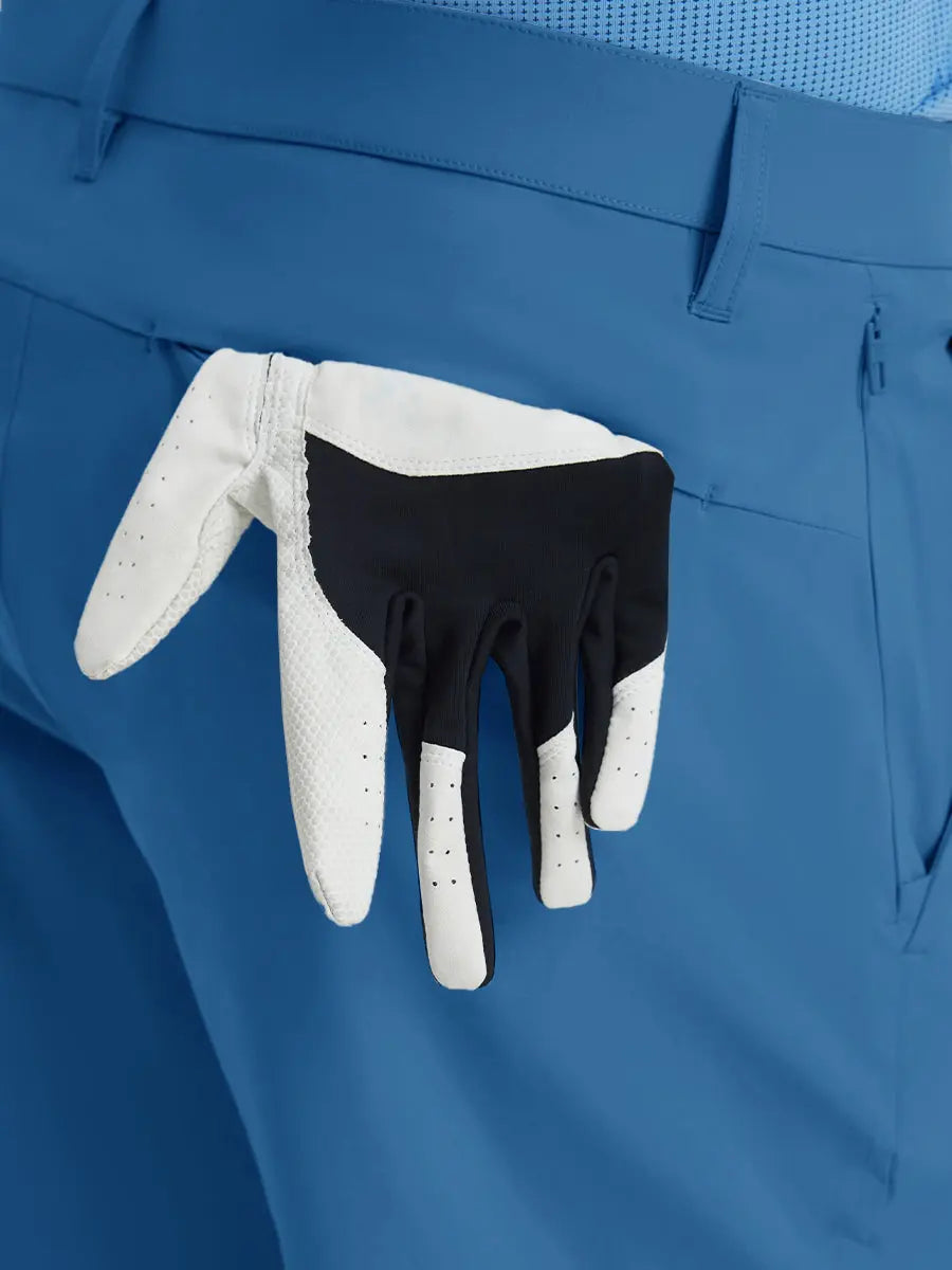 Back view of Player Fit Versatile Solid Shorts 7 Inch with golf glove tucked into right pocket – BLUE