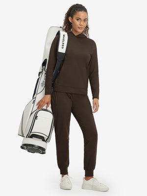 Full body model carrying a golf bag in women's lightweight hoodies pullover, relaxed fit and sporty coffee brown style