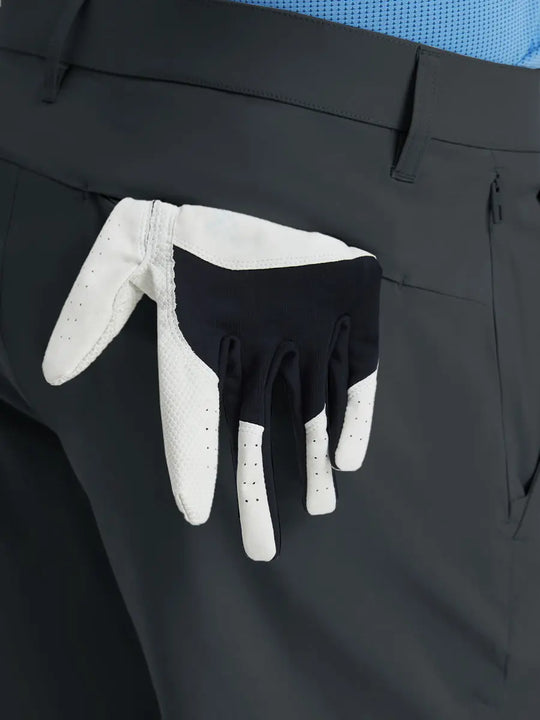 Back view of Player Fit Versatile Solid Shorts 9 Inch with golf glove tucked into right pocket – DARK GREY