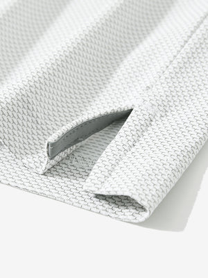 Detail of the side vent hem on the grey white feather weight jacquard polo shirts, showing the split design feature