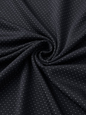 Close-up of black 4 way stretch jacquard polo fabric texture highlighting intricate woven pattern and elasticity.