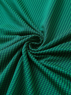 Close-up of green elegant performance jacquard polo fabric showing refined texture and subtle pattern.