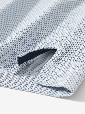 Detail of the side vent hem on the navy feather weight jacquard polo shirts, showing the split design feature