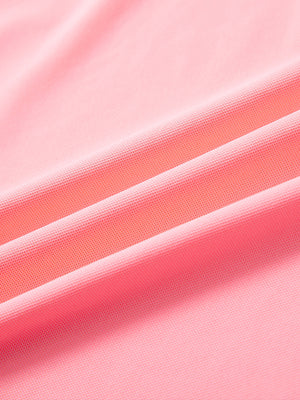 Close-up of pink ventilated pique performance polo fabric showing breathable texture.