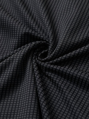 Close-up of black elegant performance jacquard polo fabric showing refined texture and subtle pattern.