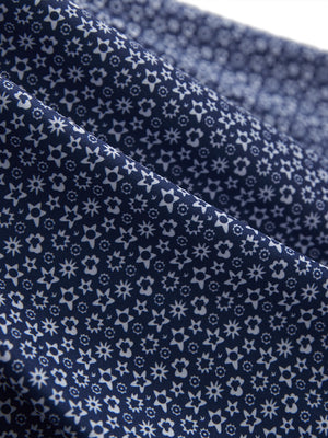 Fabric close-up of Performance quick dry print golf polos showing breathable texture in navy white floral