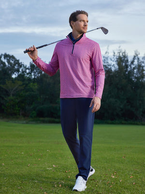 Model walking on course with club over shoulder, water-resistant fleece lined pants in navy