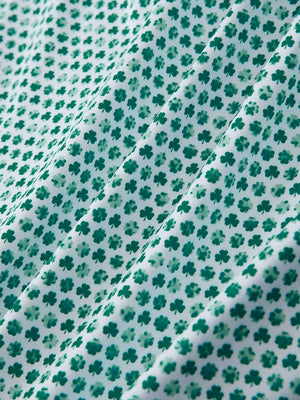 Macro view of the green lucky clover 4 way stretch print collared polo shirt fabric, showcasing the unique print design
