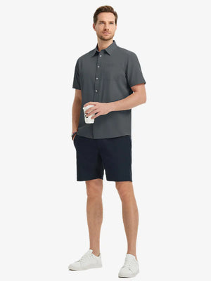 Detail shot with model holding a takeaway drink, featuring the DARK GREY polo’s side vent.